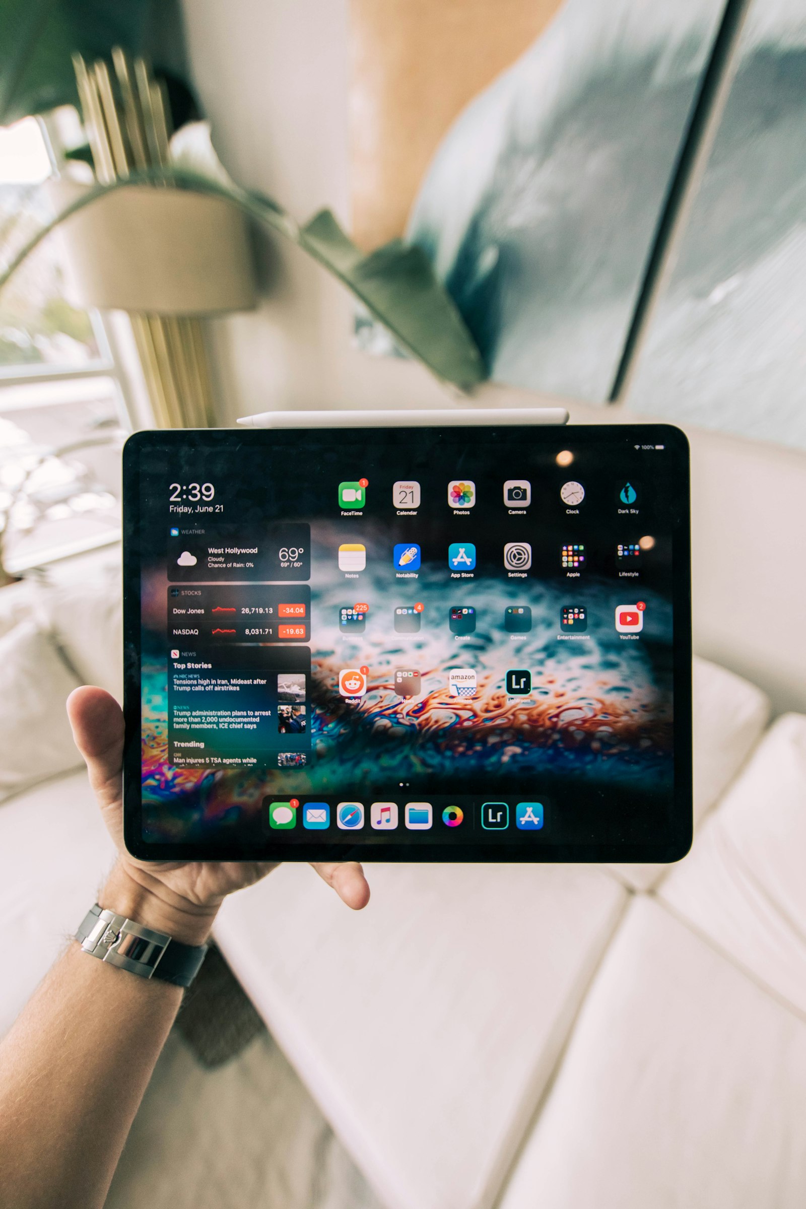 Person bedient Smart-Home-Tablet in modernem Wohnzimmer